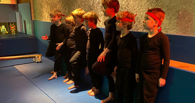 kinderen in ninja kleding op een karate mat
