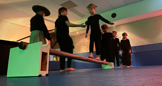 kinderen in ninja outfit balanceren over een balk