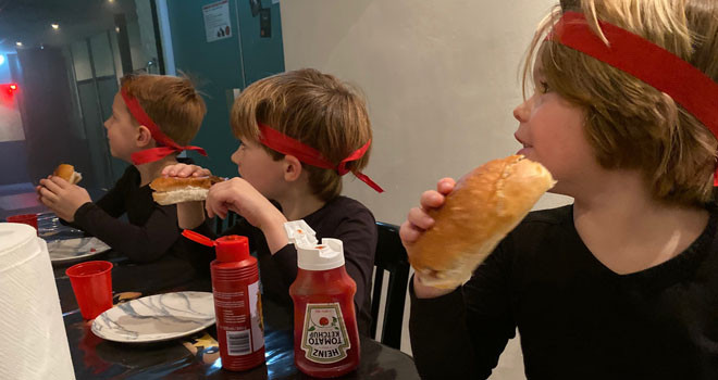 drie kinderen eten een broodje knakworst
