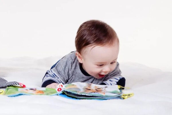 baby-liggend-met-boek-blij