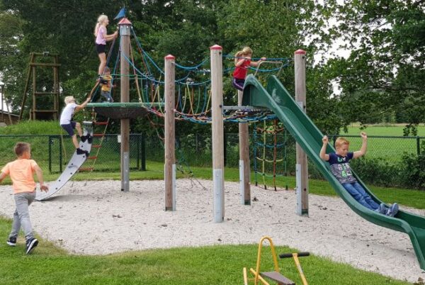 Speeltoestel met glijbaan waarop kinderen aan het spelen zijn