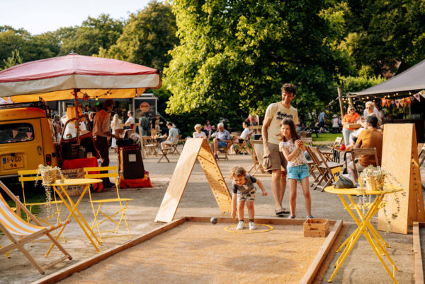 2 kinderen en een vader die spelen op een Jeu de boule baan 