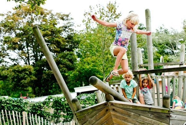 Kinderen die buitenspelen op houten boot