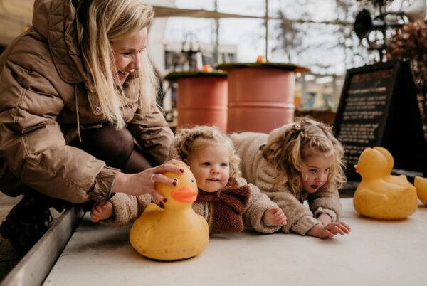 Moeder met kinderen doen curling met badeenden