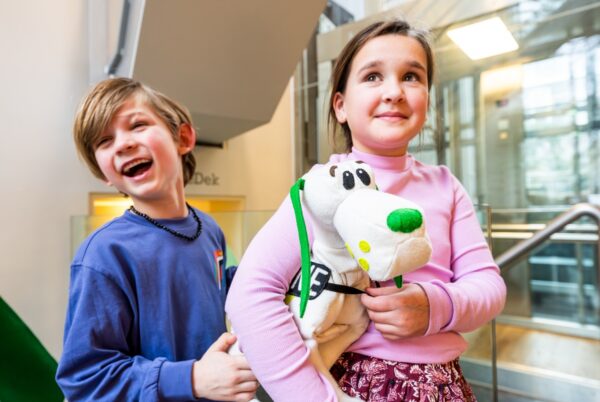 Kinderen doen de hondleiding met douanehond doerak in het belasting en douane museum