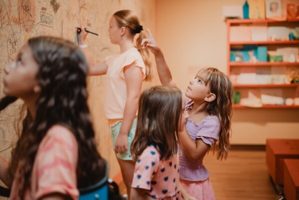 Kinderen tekenen en schrijven op muur bij het Dordrechts Museum