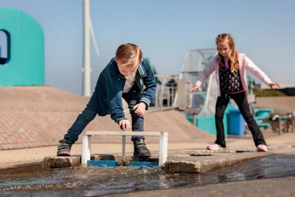 Kinderen spelen met waterbaan buiten