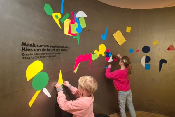 Kinderen maken fantasiedier op wand
