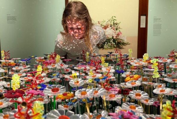 Meisje bij bloemenzee met lampjes