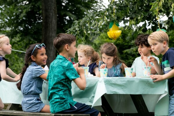 Kinderen aan tafel tijdens een buitenfeestje