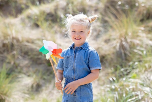 Meisje speelt met waaier op het strand